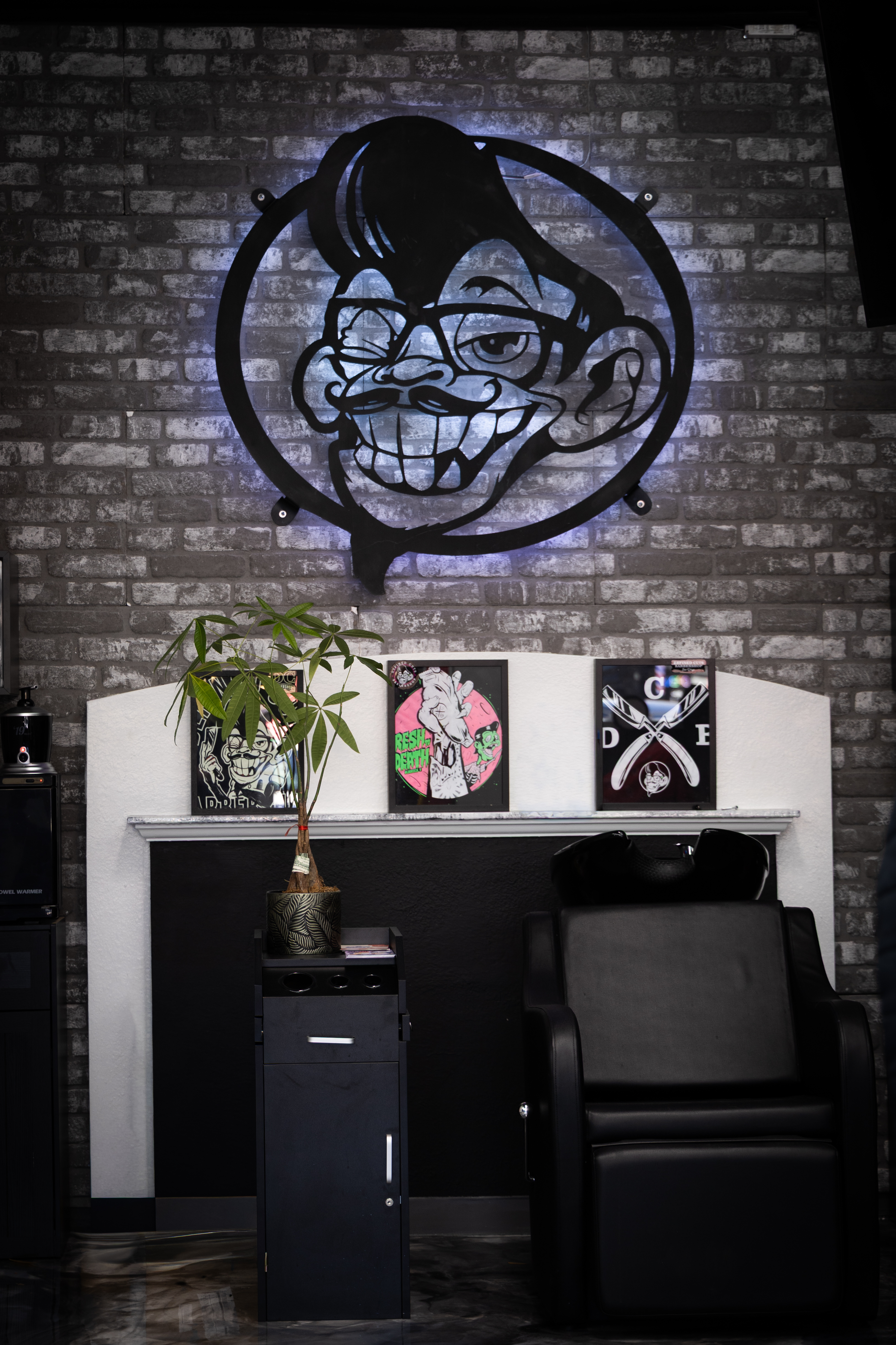 Defined Cuts mascot logo on the brick accent wall